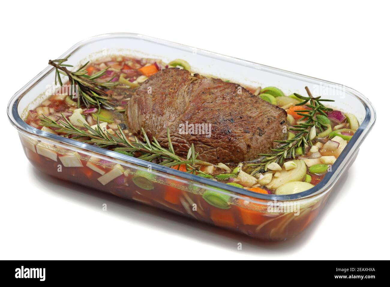 Bistecca di manzo con rosmarino ramato e verdure in una ciotola di vetro isolato su sfondo bianco Foto Stock