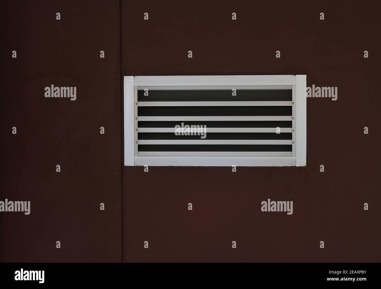Griglia di ventilazione in metallo per closeup installata sulla parete marrone Foto Stock