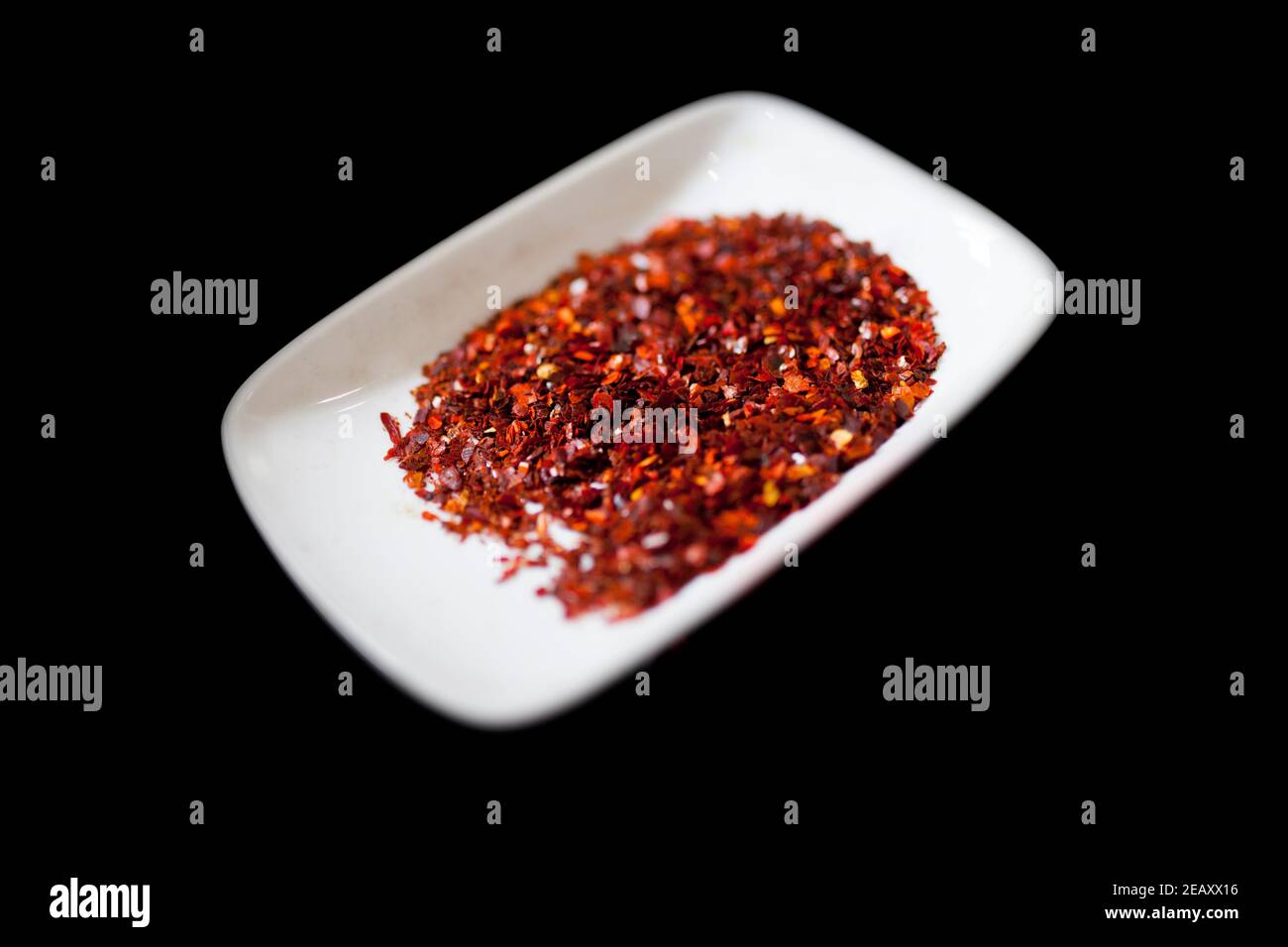 Paprika affumicata di Jaraiz in fiocchi. Isolato su nero Foto Stock