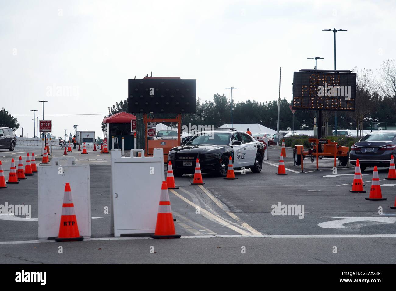 Un'auto del Dipartimento di polizia di Anaheim all'ingresso del sito di vaccinazione di massa COVID-19 del Super Point-of-Distribution Coronavirus in un parcheggio Disneyland, Mer Foto Stock