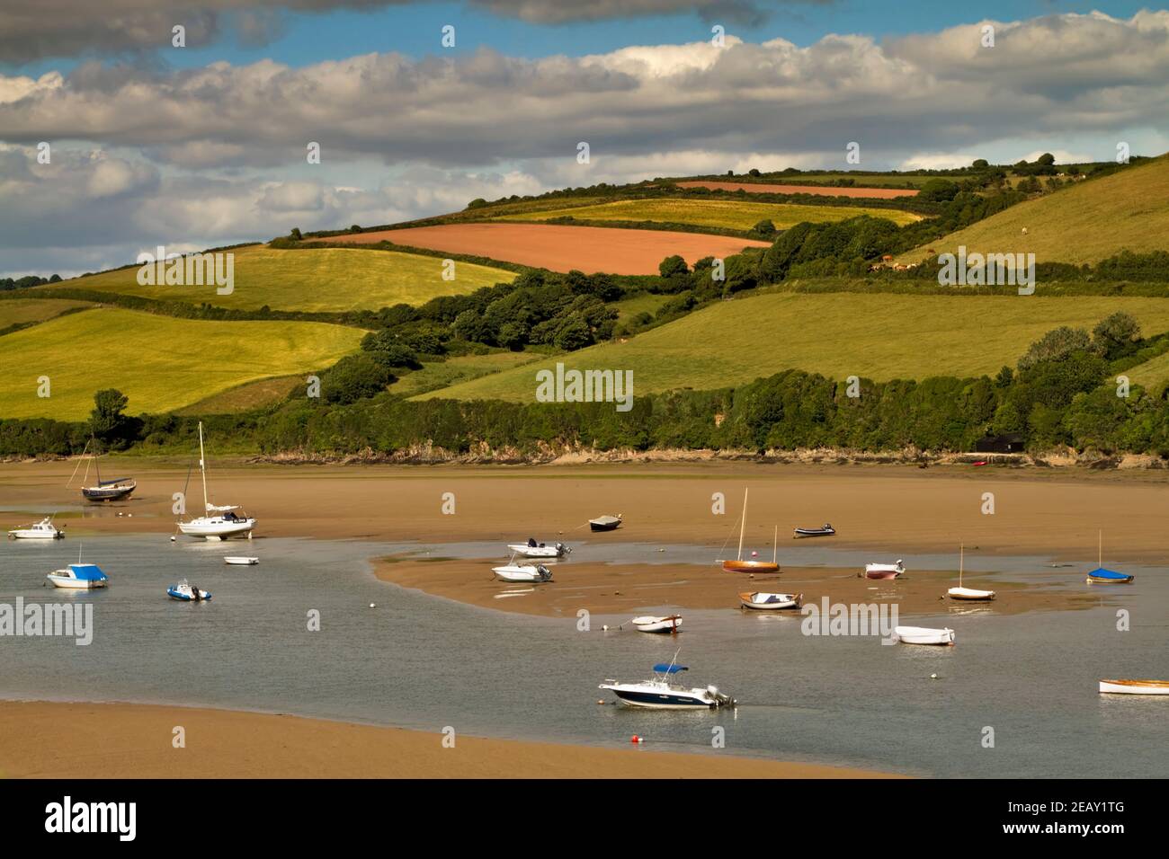 L'estuario del fiume Avon, Bantham Beach, Devon. Barche a vela e gommoni a bassa marea con la campagna ondulata alle spalle. Foto Stock