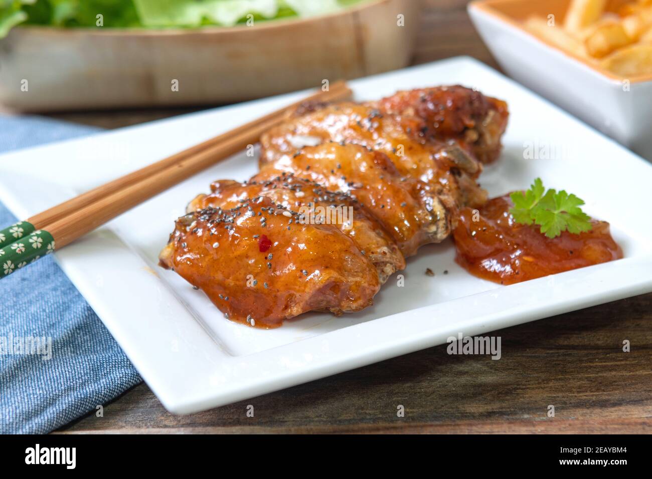 ali di pollo al chutney di mango con patatine fritte e insalata Foto Stock