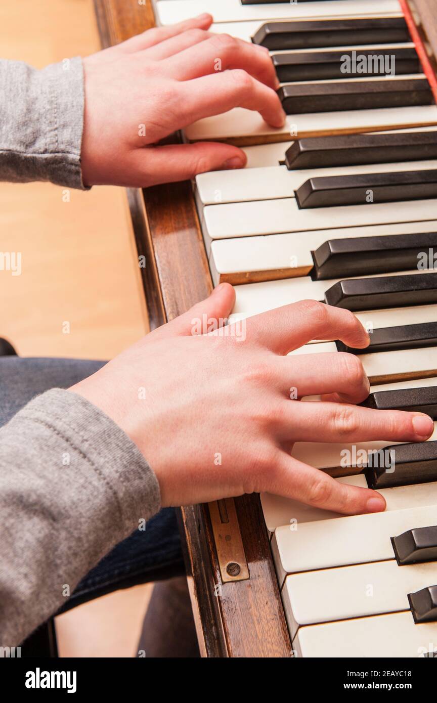 Un ragazzo di 13 anni suona su un pianoforte Foto Stock