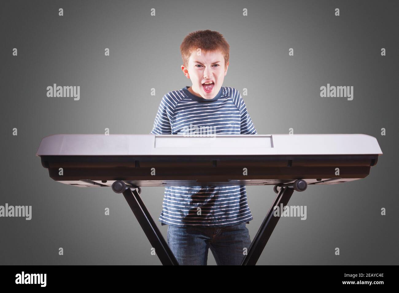 Un ragazzo che suona un pianoforte elettrico Foto Stock