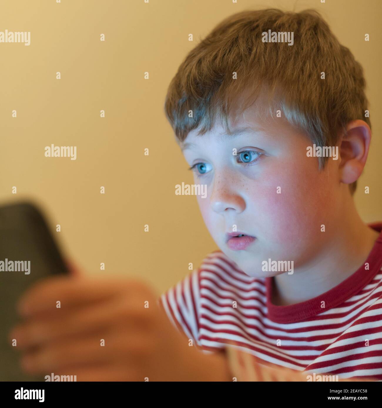 Un ragazzo di 9 anni che usa un tablet a casa Foto Stock