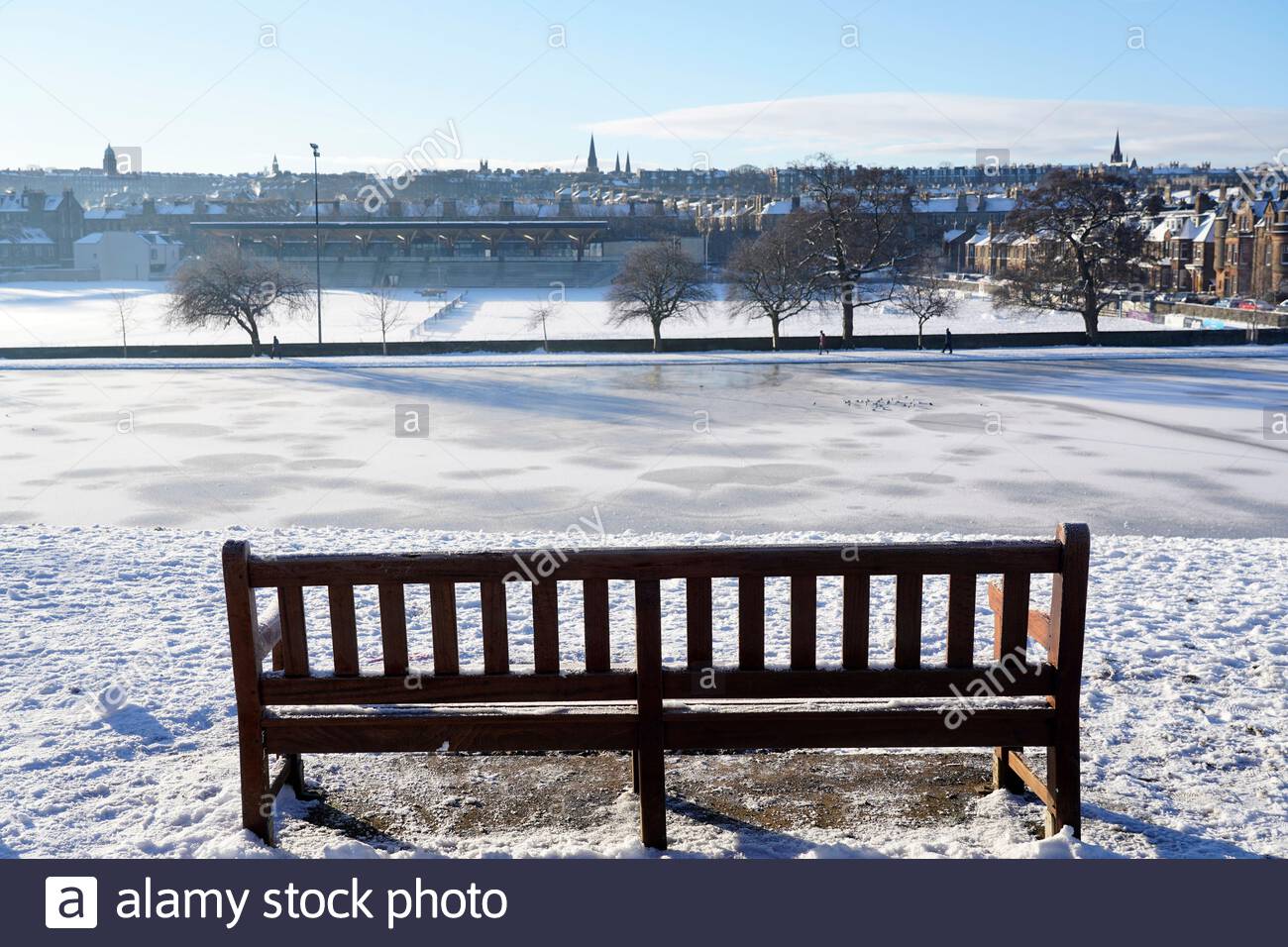 Edimburgo, Scozia, Regno Unito. 11 Feb 2021. La gente gode di una gloriosa mattina soleggiata ma gelida in un parco innevato Inverleith. Vista su un laghetto ghiacciato di Inverleith. Credit: Craig Brown/Alamy Live News Foto Stock