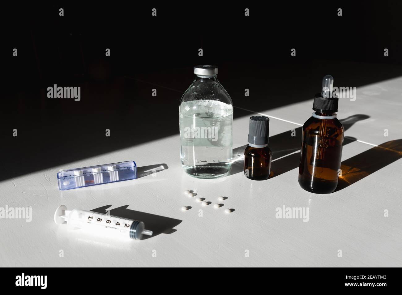 Medicina, cuscini e altri farmaci su un tavolo bianco con sfondo nero. Foto Stock