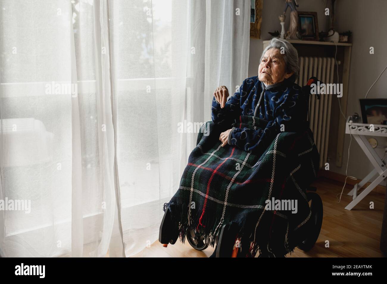 Ritratto vecchia donna malata seduta in sedia a rotelle a casa. Terza età, concetto di assistenza per anziani domestici. Foto Stock