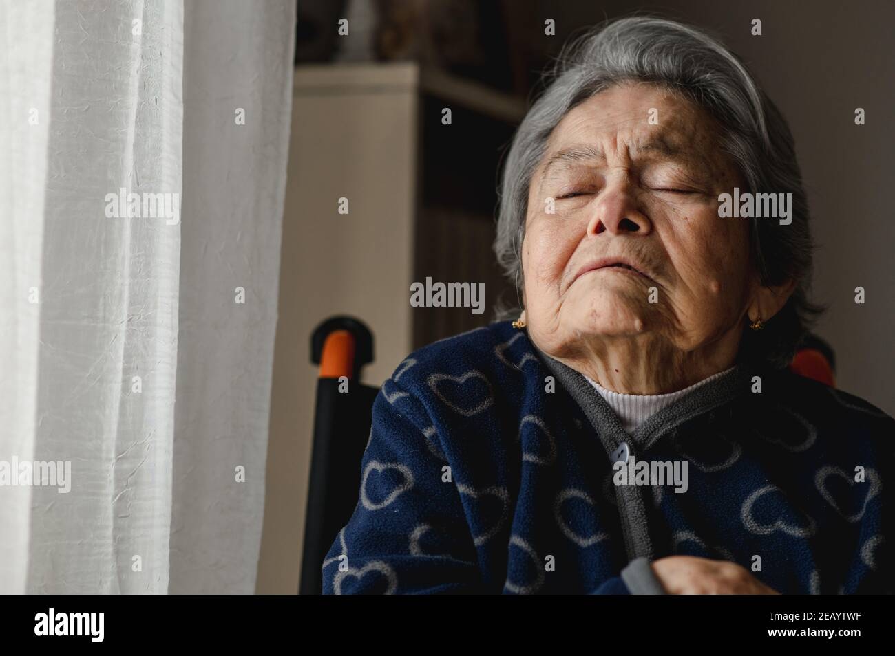 Ritratto vecchia donna malata seduta in sedia a rotelle a casa. Anziano con occhi chiusi e volto confuso per perdita di memoria e degenerative disease.Third age, ho Foto Stock