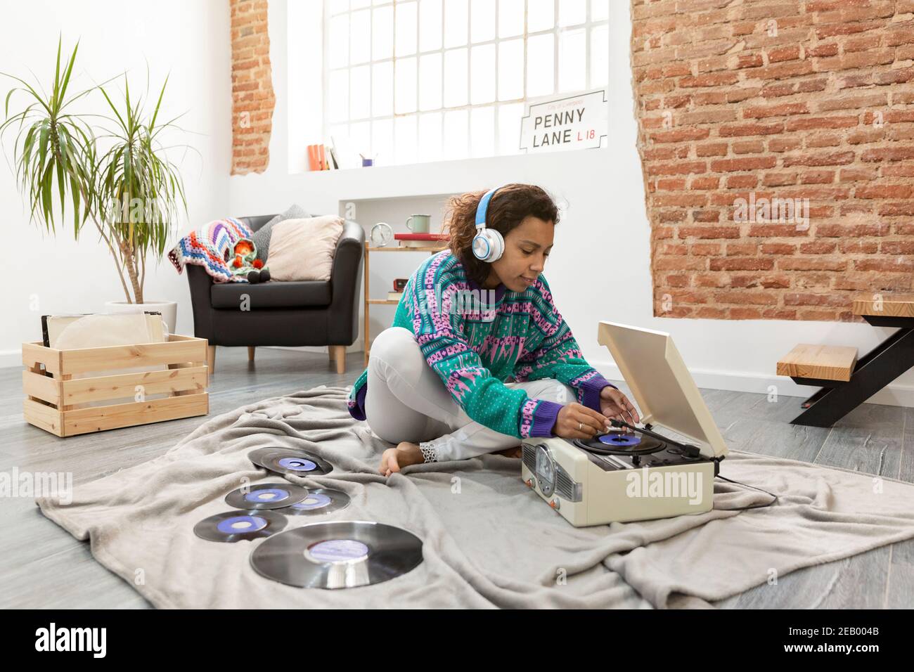 Donna ispanica che ascolta la musica e si diverte a casa. Spazio per il testo. Foto Stock