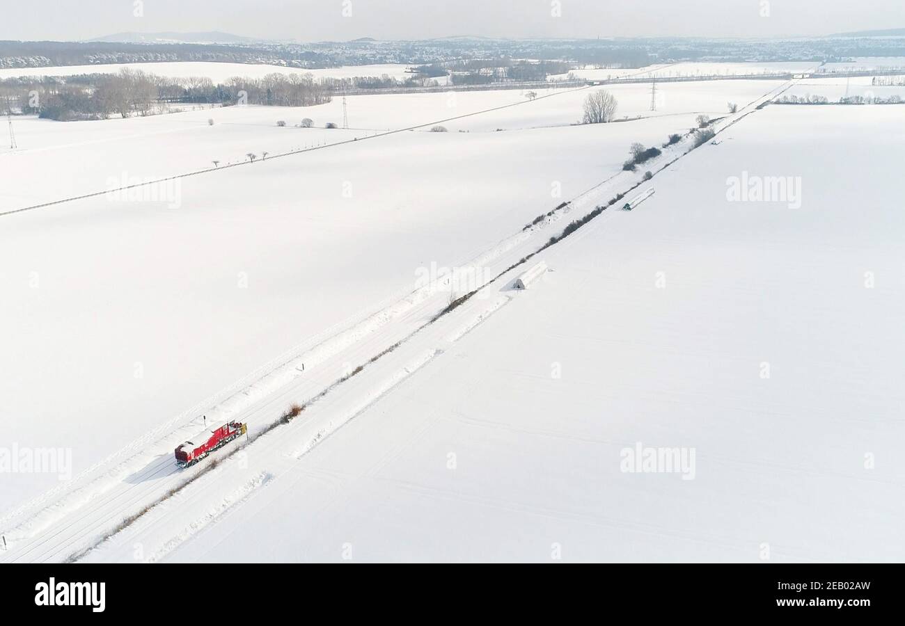 Brunswick, Germania. 11 Feb 2021. Un soffiatore di neve Deutsche Bahn libera la linea ferroviaria Braunschweig - Wolfenbüttel dalla neve. Deutsche Bahn utilizza attrezzature pesanti per cercare di rendere passabili nuovamente le linee ferroviarie innevate. Numerose connessioni vengono ancora annullate. Credit: Julian Stratenschulte/dpa/Alamy Live News Foto Stock