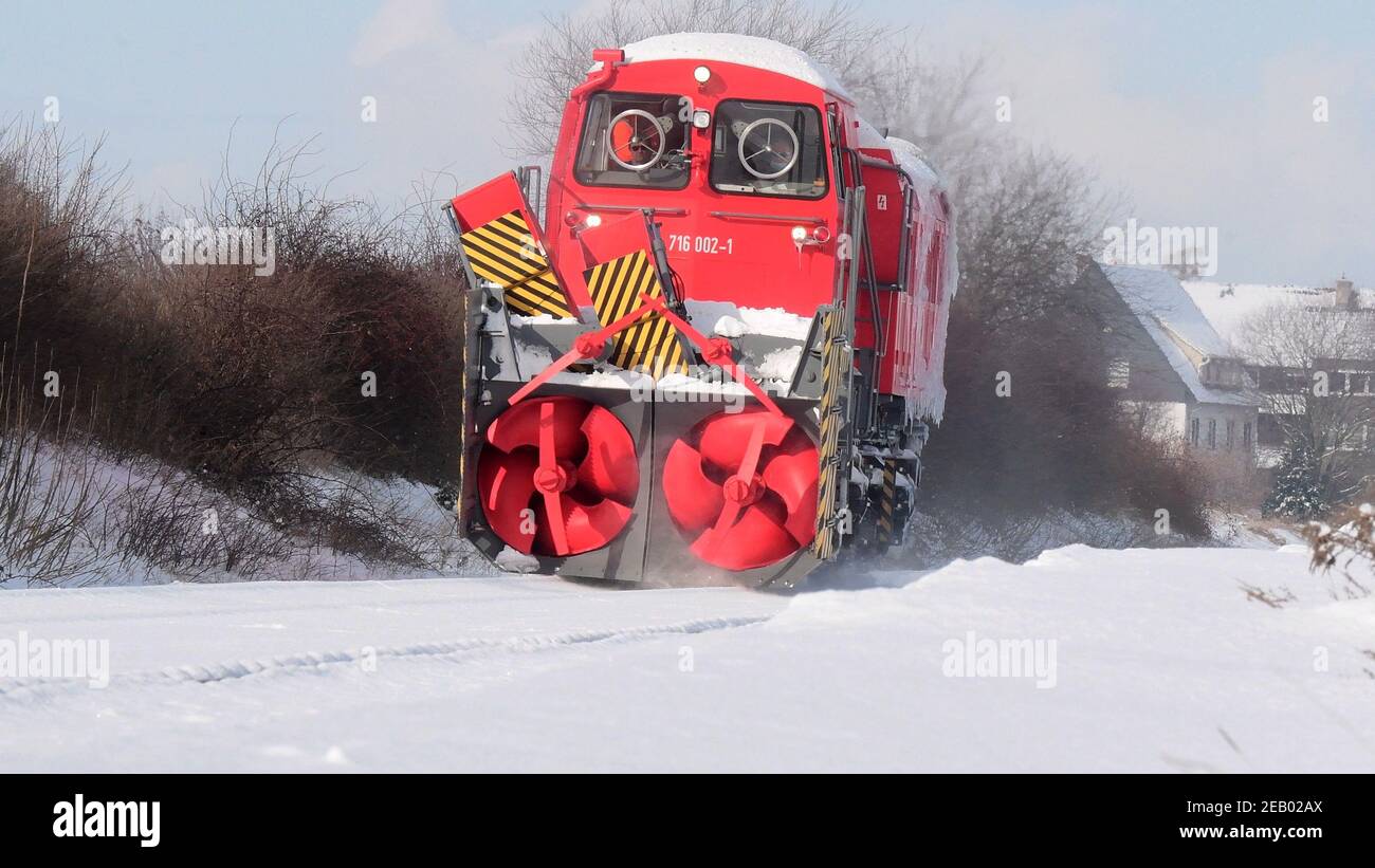 Brunswick, Germania. 11 Feb 2021. Un soffiatore di neve Deutsche Bahn libera la linea ferroviaria Braunschweig - Wolfenbüttel dalla neve. Deutsche Bahn utilizza attrezzature pesanti per cercare di rendere passabili nuovamente le linee ferroviarie innevate. Numerose connessioni vengono ancora annullate. Credit: Julian Stratenschulte/dpa/Alamy Live News Foto Stock