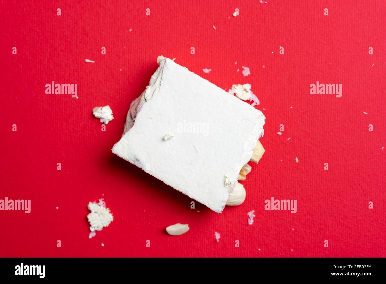 Pezzo di torrone italiano su sfondo rosso. Vista dall'alto Foto Stock