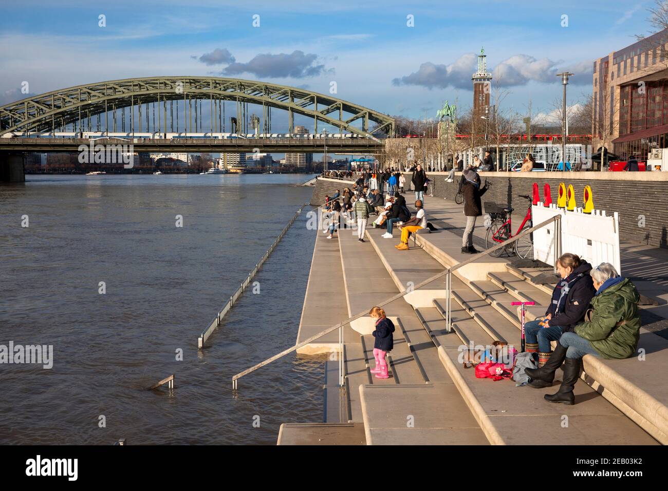 Alluvione del Reno il 4 febbraio. 2021, persone sulla scala parzialmente allagata al viale Reno in Deutz, vista sul ponte Hohenzollern, Colo Foto Stock