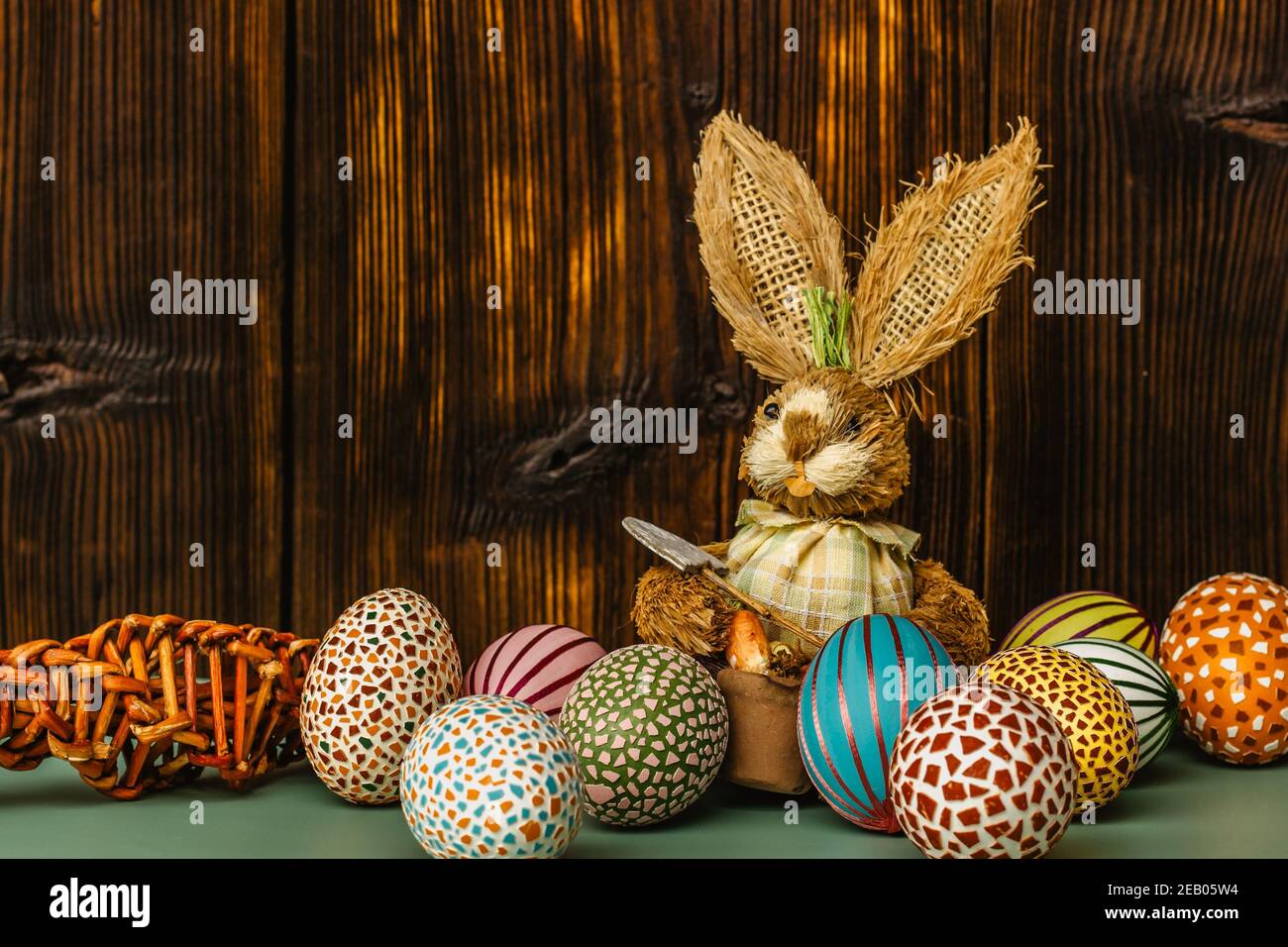 Happy card.colorful Pasqua dipinta a mano decorate uova di Pasqua, fai da te coniglietto di legno divertente. Uova di Pasqua fatte a mano sulla tabella copia space.Spring decorazione indietro Foto Stock
