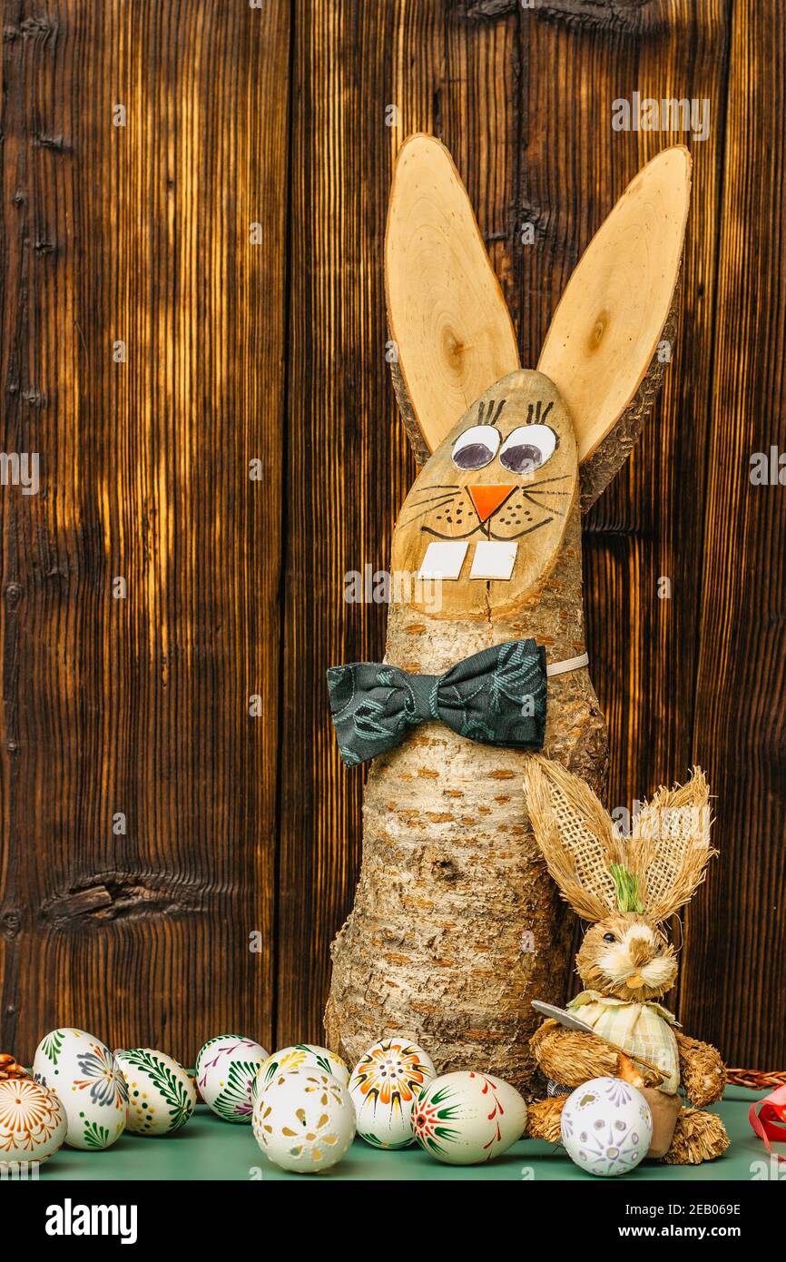Happy card.colorful Pasqua dipinta a mano decorate uova di Pasqua, fai da te coniglietto di legno divertente. Uova di Pasqua fatte a mano sulla tabella copia space.Spring decorazione indietro Foto Stock