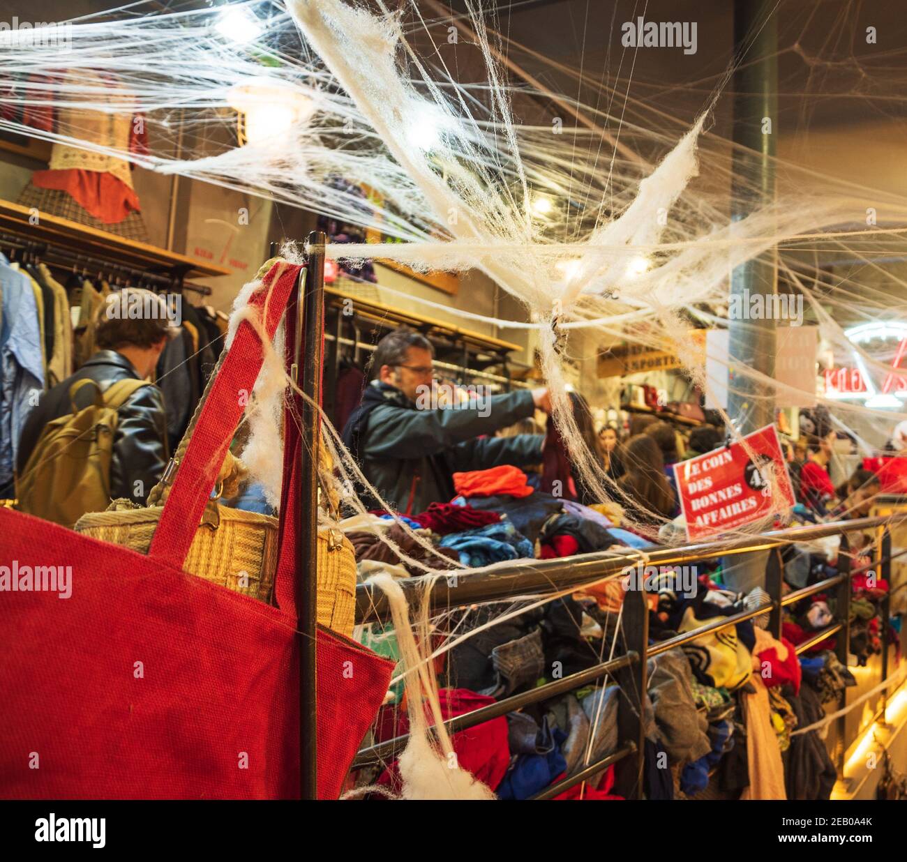 La gente sceglie e compra i vestiti in Kilo Store, negozio di abbigliamento  vintage che vende i vestiti dal peso nel quartiere di Marais, decorato per  Halloween. Parigi Francia Foto stock -