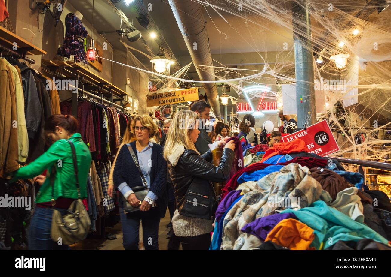 La gente sceglie e compra i vestiti in Kilo Store, negozio di abbigliamento  vintage che vende i vestiti dal peso nel quartiere di Marais, decorato per  Halloween. Parigi Francia Foto stock -