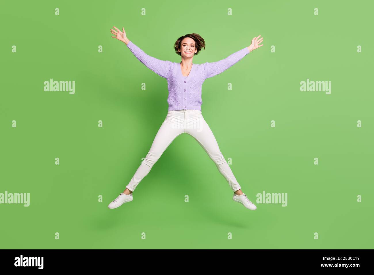 Ritratto a lunghezza intera di signora allegra salto alto fare stella figura sorriso togolo isolato su sfondo di colore verde Foto Stock