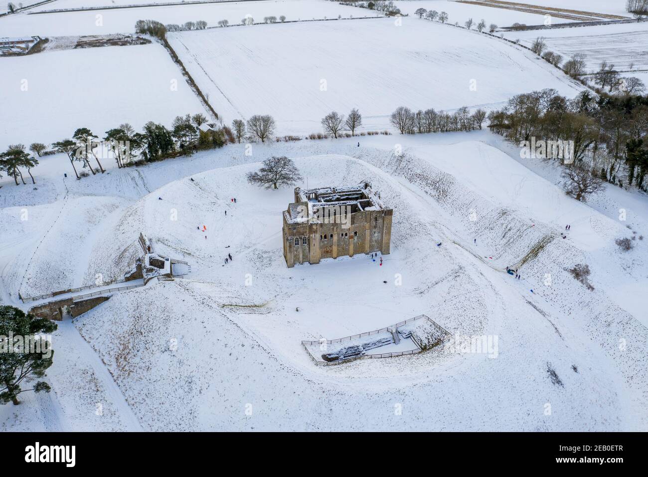 La foto datata 10 febbraio mostra le persone che slittano dal Castello Rising in Norfolk che confina con la tenuta di Sandringham che è ora coperto dalla recente nevicata.Castle Rising è una fortificazione medievale in rovina nel villaggio di Castle Rising, Norfolk.IT è stato costruito subito dopo il 1138 da William d'Aubigny II L'Ufficio MET ha messo in atto un avvertimento giallo per la neve nel sud-est e nell'est dell'Inghilterra e per la neve e il ghiaccio nel nord dell'Inghilterra. Oggi vedrà un altro giorno freddo, ma sarà meno ventoso per molti, e l'ovest avrà alcuni buoni incantesimi di sole. Gli acquazzoni di neve sono attesi per continu Foto Stock