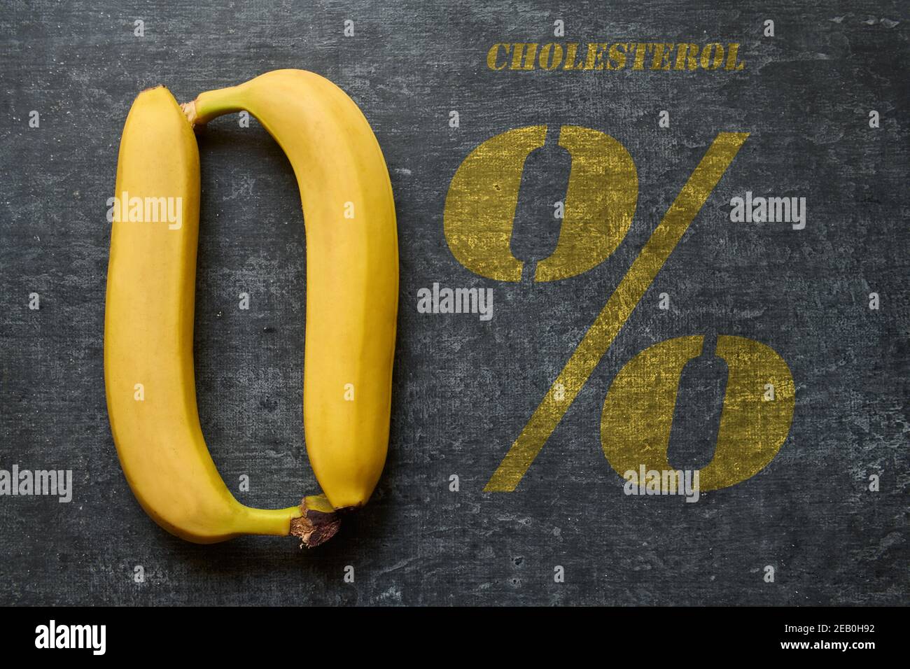 Cibo senza colestirina, due banane disposte sotto forma di zero, l'iscrizione colestirolo zero per cento, concetto di alimentazione sana Foto Stock