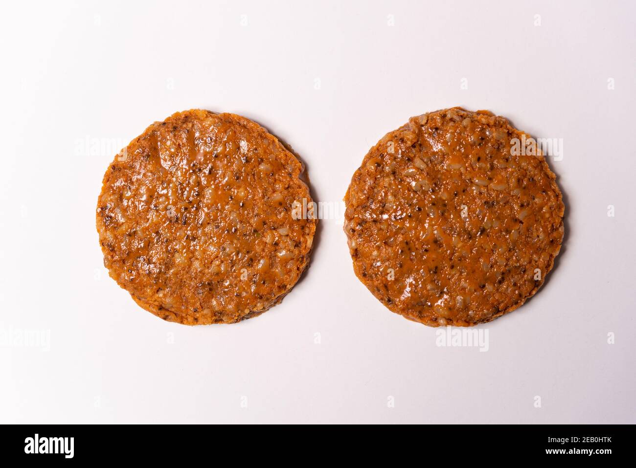 due hamburger vegan grezzi su sfondo bianco. hamburger vegetariano con spazio per la copia Foto Stock
