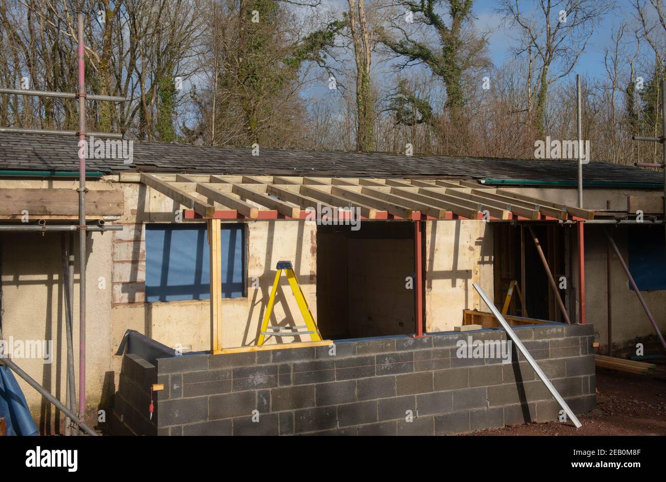 Impalcatura rotonda il tetto di un cottage in fase di estensione e ristrutturazione in un cantiere in Devon Rurale, Inghilterra, Regno Unito Foto Stock