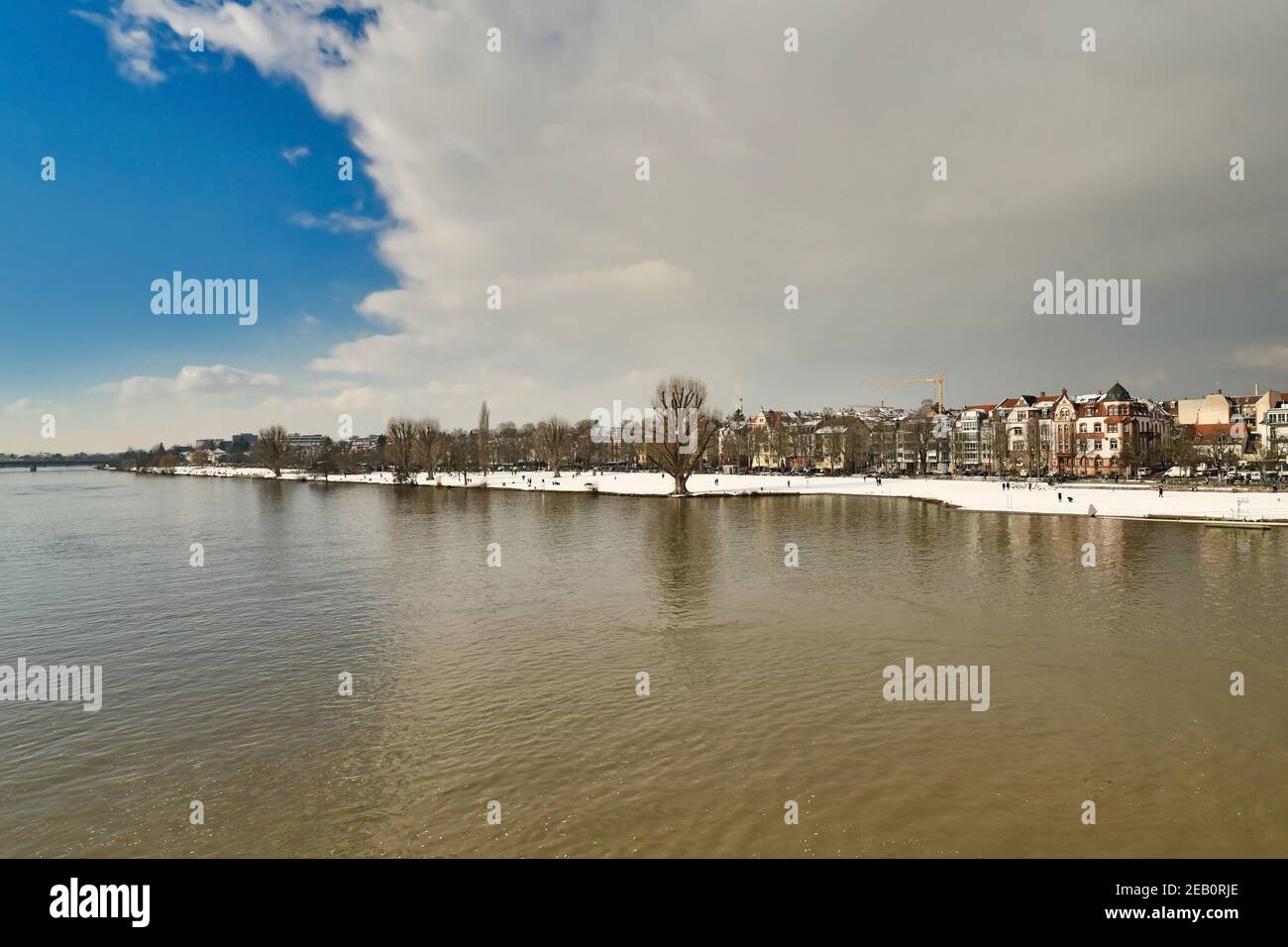 Heidelberg, Germania - Febbraio 2021: Nuvole grigie che coprono il cielo blu sulla neve coperta fiume Neckar in inverno Foto Stock