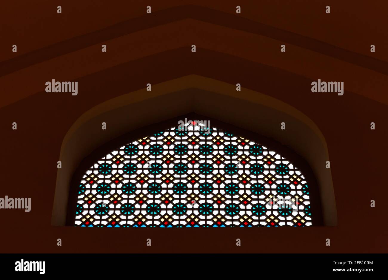 Parete scura con antica finestra in vetro colorato con geometrie arabe modello Foto Stock