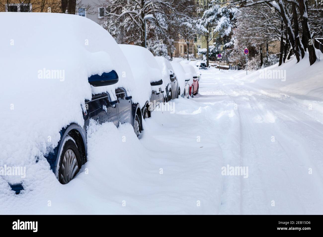 Le auto parcheggiate dopo una nevicata pesante sono completamente coperte di neve Foto Stock