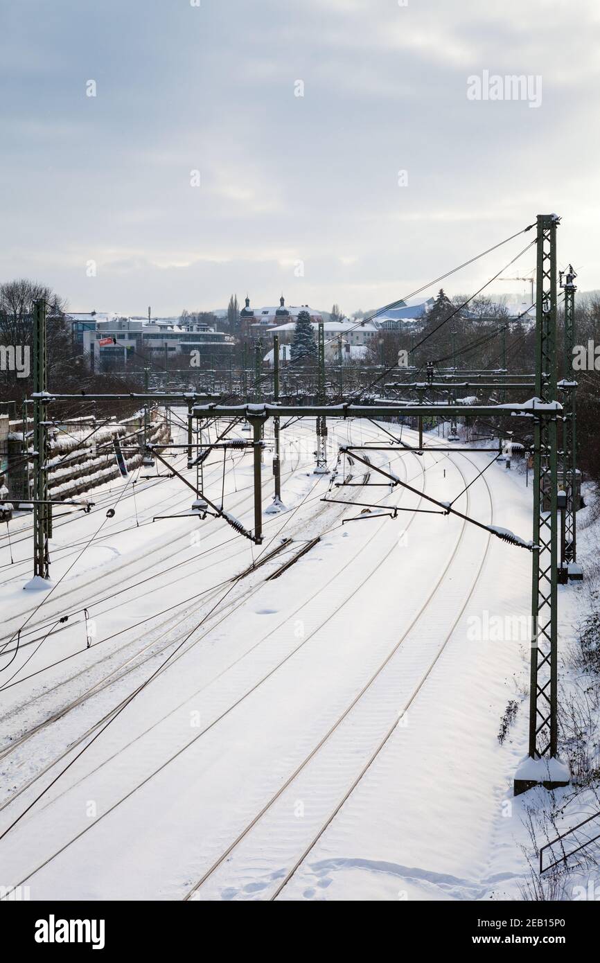 Binari del treno urbano coperti di neve con luce soffusa da il lato Foto Stock