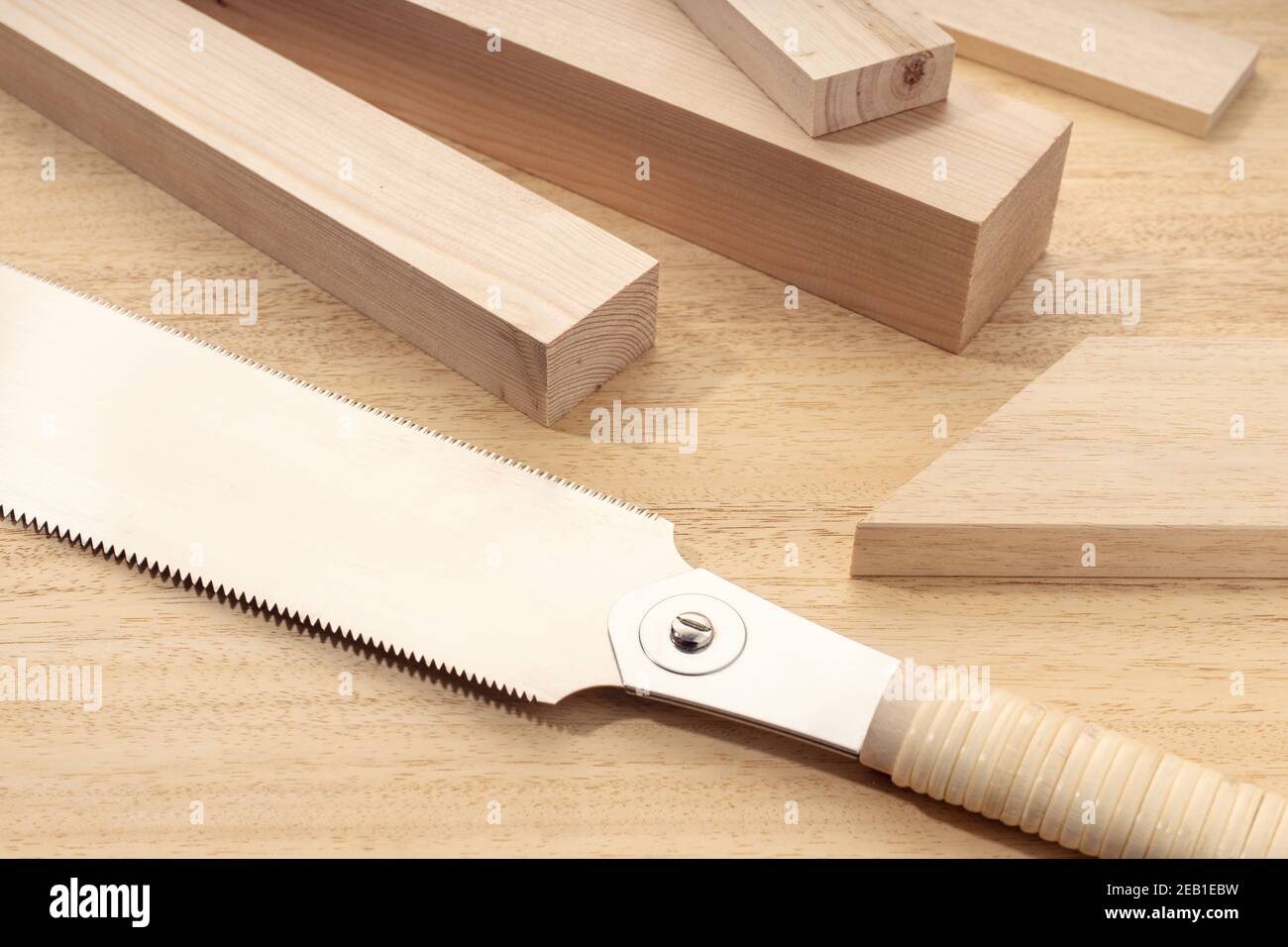 Gruppo di materiale di legno assortito e una sega a mano giapponese. Legno di carpenteria, materiale tagliato o legno concetto. Primo piano Foto Stock