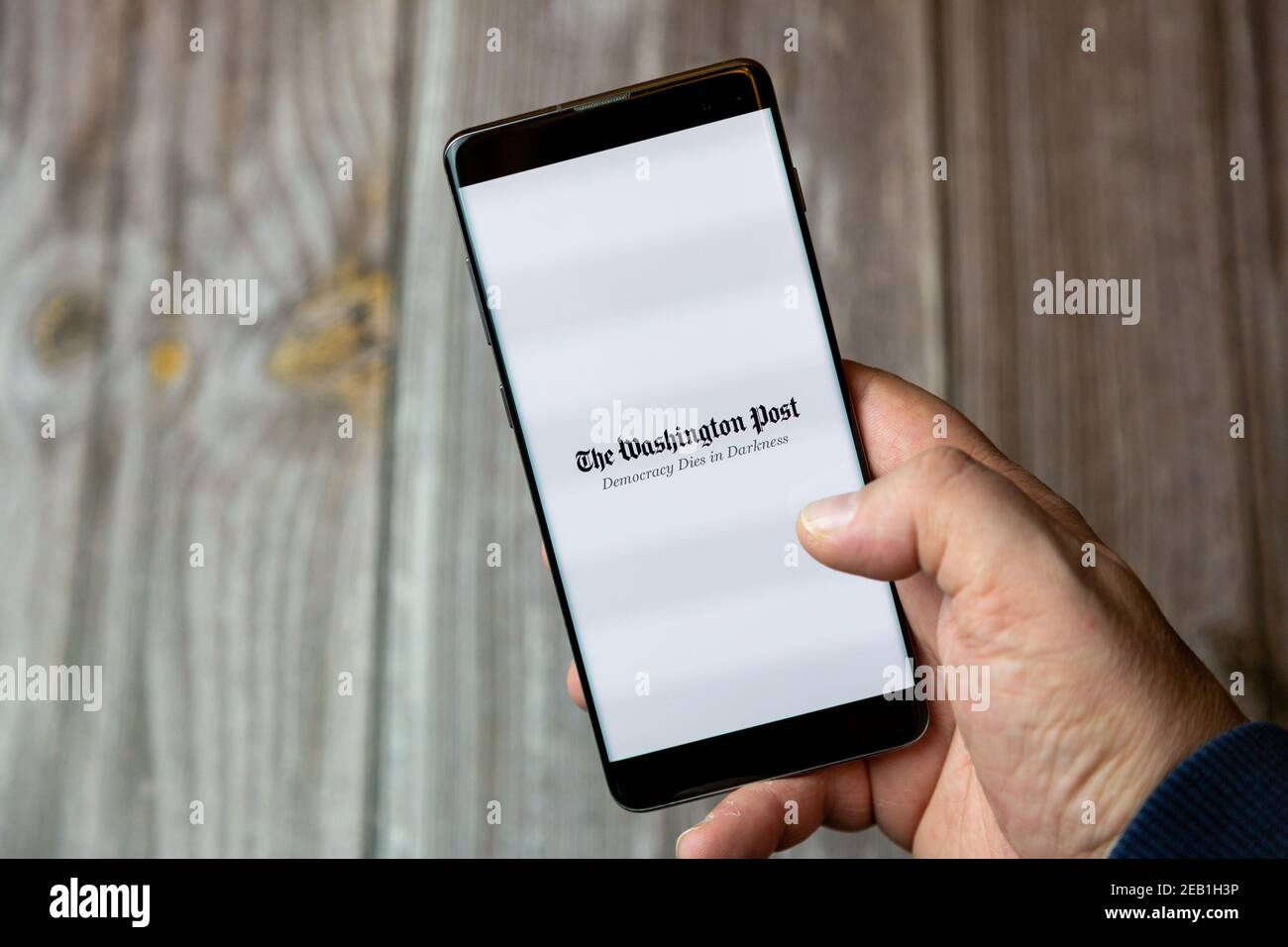 Un telefono cellulare o un telefono cellulare tenuto da un Mano con l'app Washington Post aperta sullo schermo Foto Stock