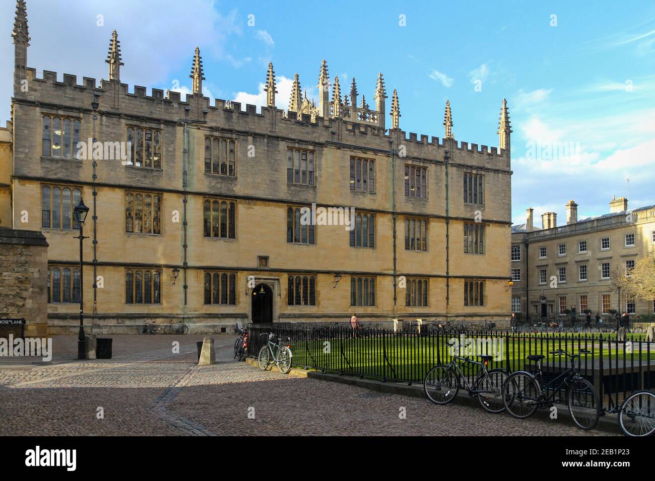 Edificio della biblioteca Bodleian in Radcliffe Square, Università di Oxford. Edifici storici in pietra. Terreno di ciottoli. La gente cammina. Biciclette a ringhiere Foto Stock