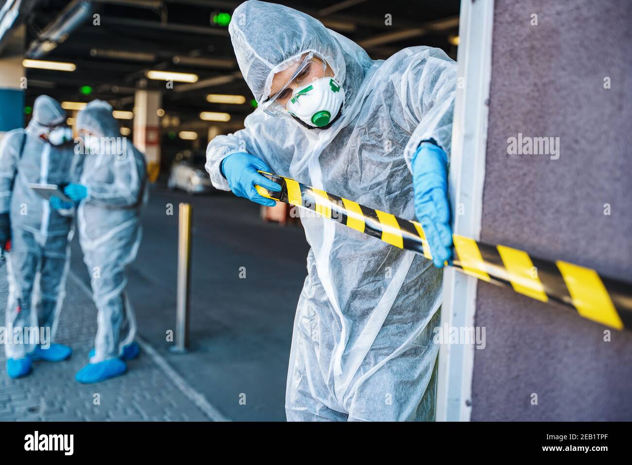 Operaio sanitario che si allontana da un'area urbana con nastro barriera durante un focolaio Foto Stock