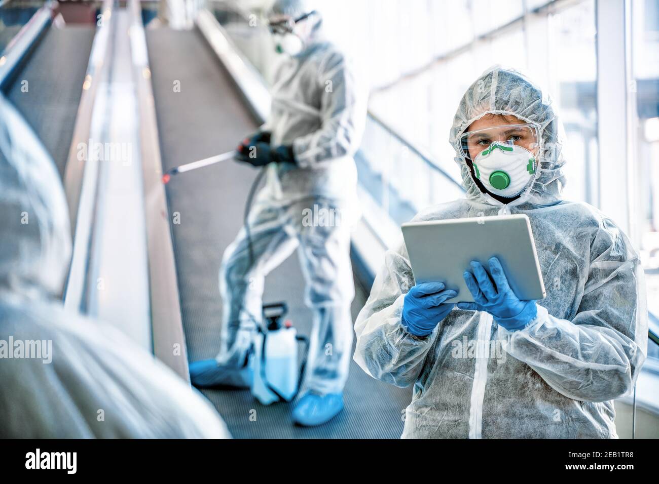 Operatori sanitari che indossano abiti di nocciolo che lavorano insieme nel centro commerciale, per controllare un focolaio di virus in città Foto Stock