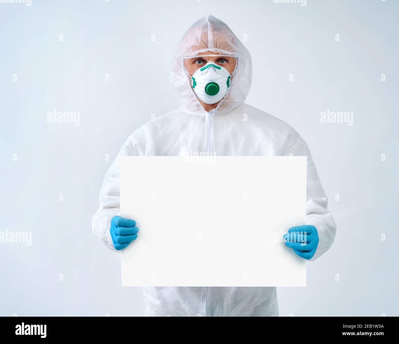 Operatore sanitario in tuta protettiva e maschera medica contiene spazio vuoto per la copia. Concetto di assistenza sanitaria. Foto Stock