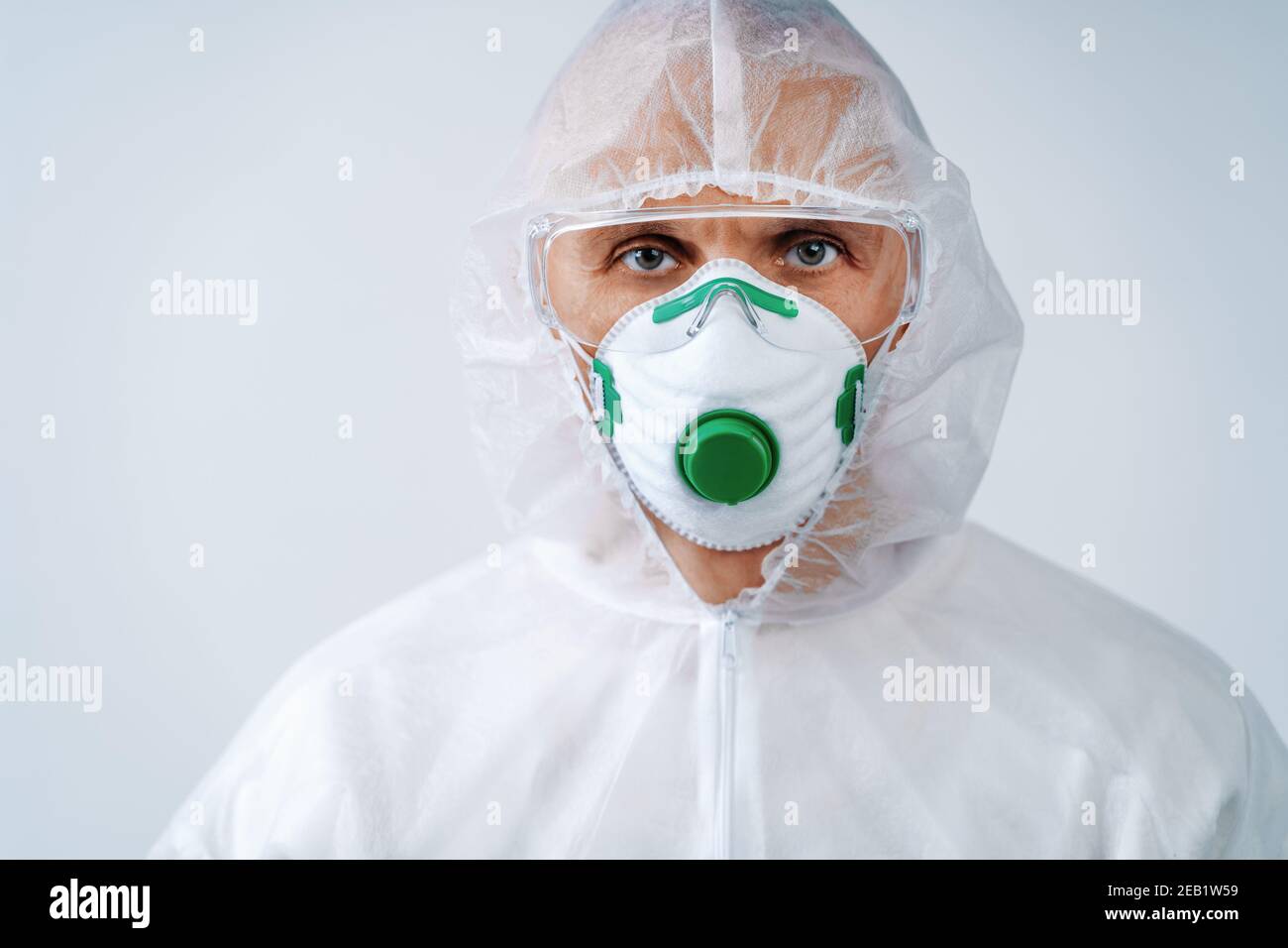 Operatore sanitario in tuta protettiva e maschera medica su sfondo bianco. Concetto di assistenza sanitaria. Foto Stock