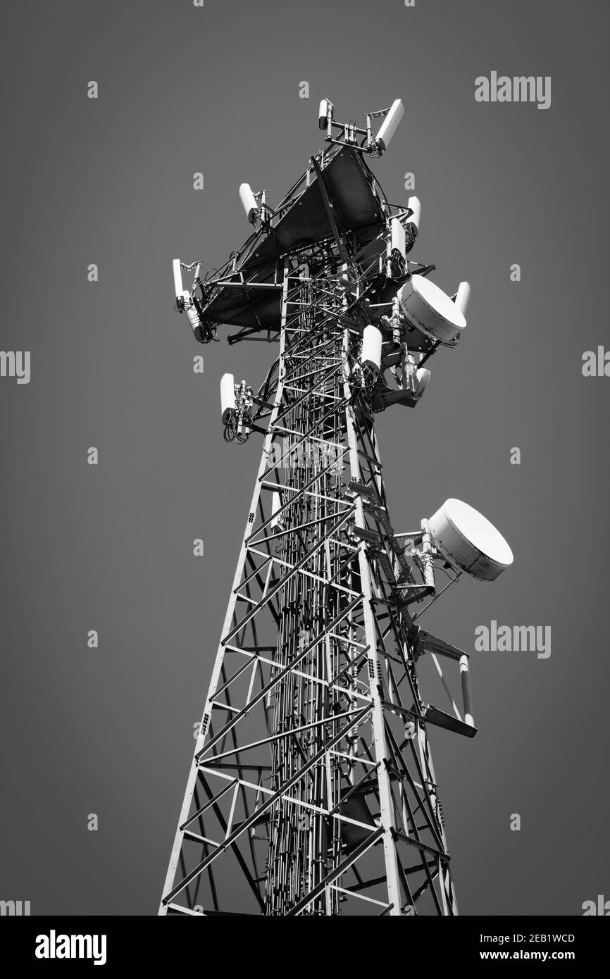 Immagine in scala di grigi di una torre metallica con antenne per cellulari Foto Stock
