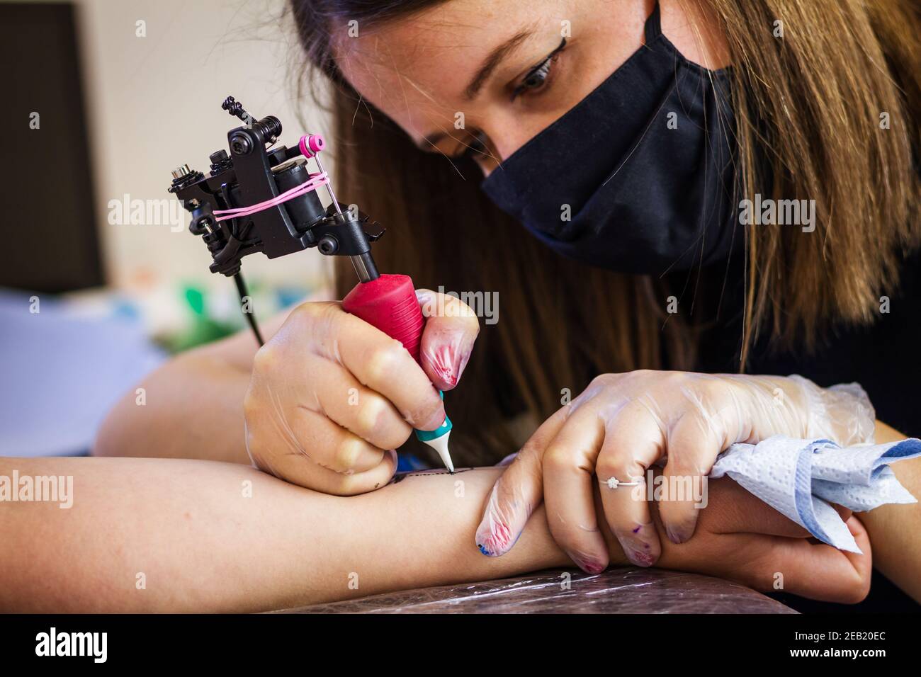 Donna tatuaggio maestro tatuaggio mano femminile in studio. Occupazione creativa Foto Stock
