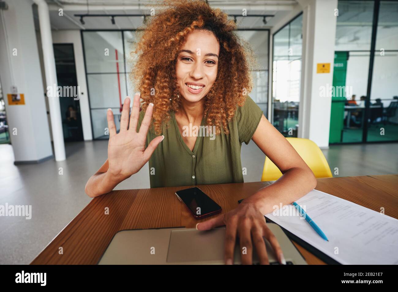 Giovane donna amichevole che ha una videochiamata sul suo computer Foto Stock