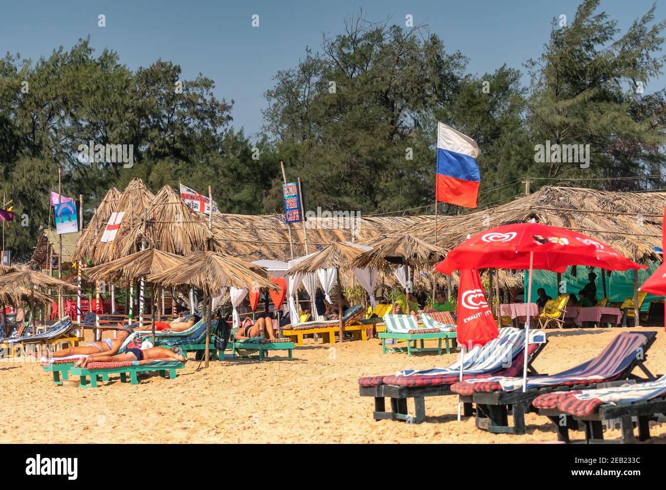 Ed CALANGUTE, Goa, INDIA 3 GENNAIO 2019: Bella spiaggia con letto in riva al mare e ombrelloni, abbronzatura turisti russi, bandiera russa sulla località indiana Foto Stock