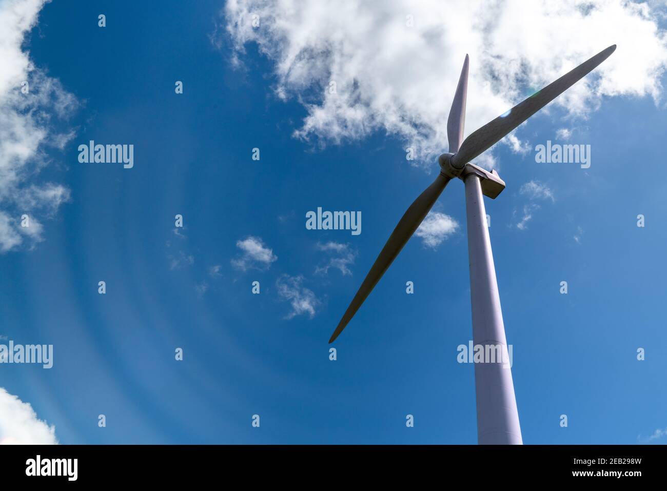 La turbina eolica emette potenti raffiche di energia. Turbina eolica singola ripresa in prospettiva dal basso Foto Stock