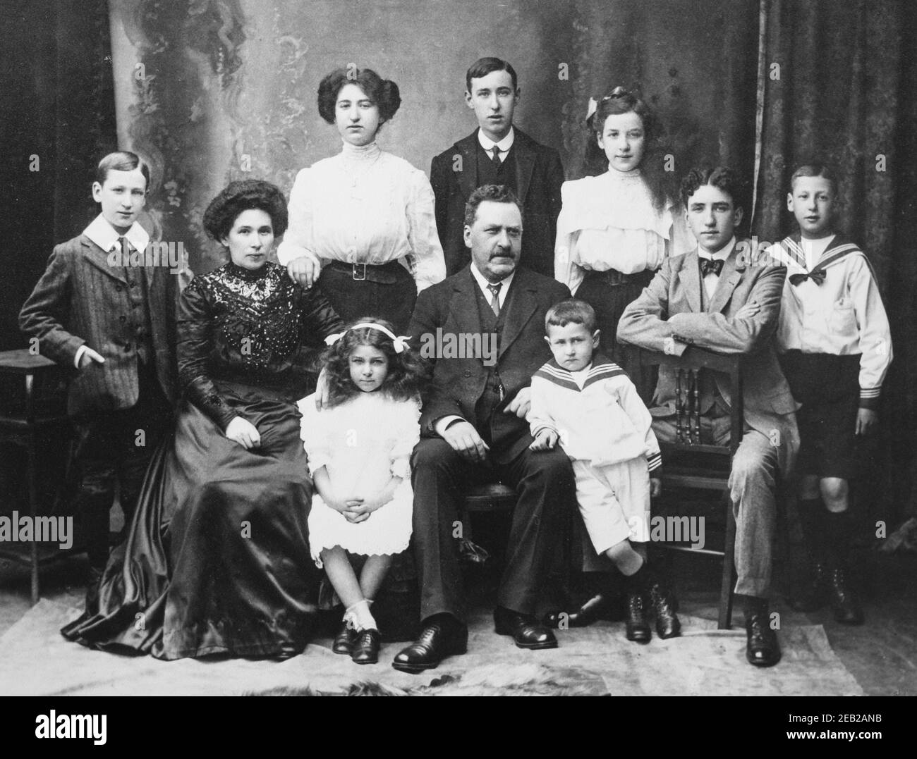 Fotografia in studio monocromo vintage di una grande famiglia caucasica edoardiana. Fotografato a Glasgow, Scozia, circa 1906. Foto Stock