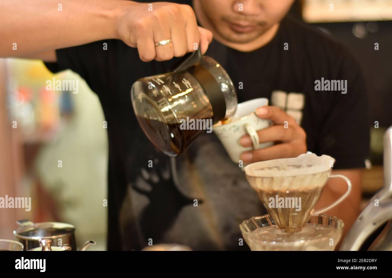 Il barista cafè prepara espresso e bevande al caffè vietnamita presso la caffetteria. Ritratto di un dipendente della caffetteria che prepara il caffè al bar. Il processo o Foto Stock