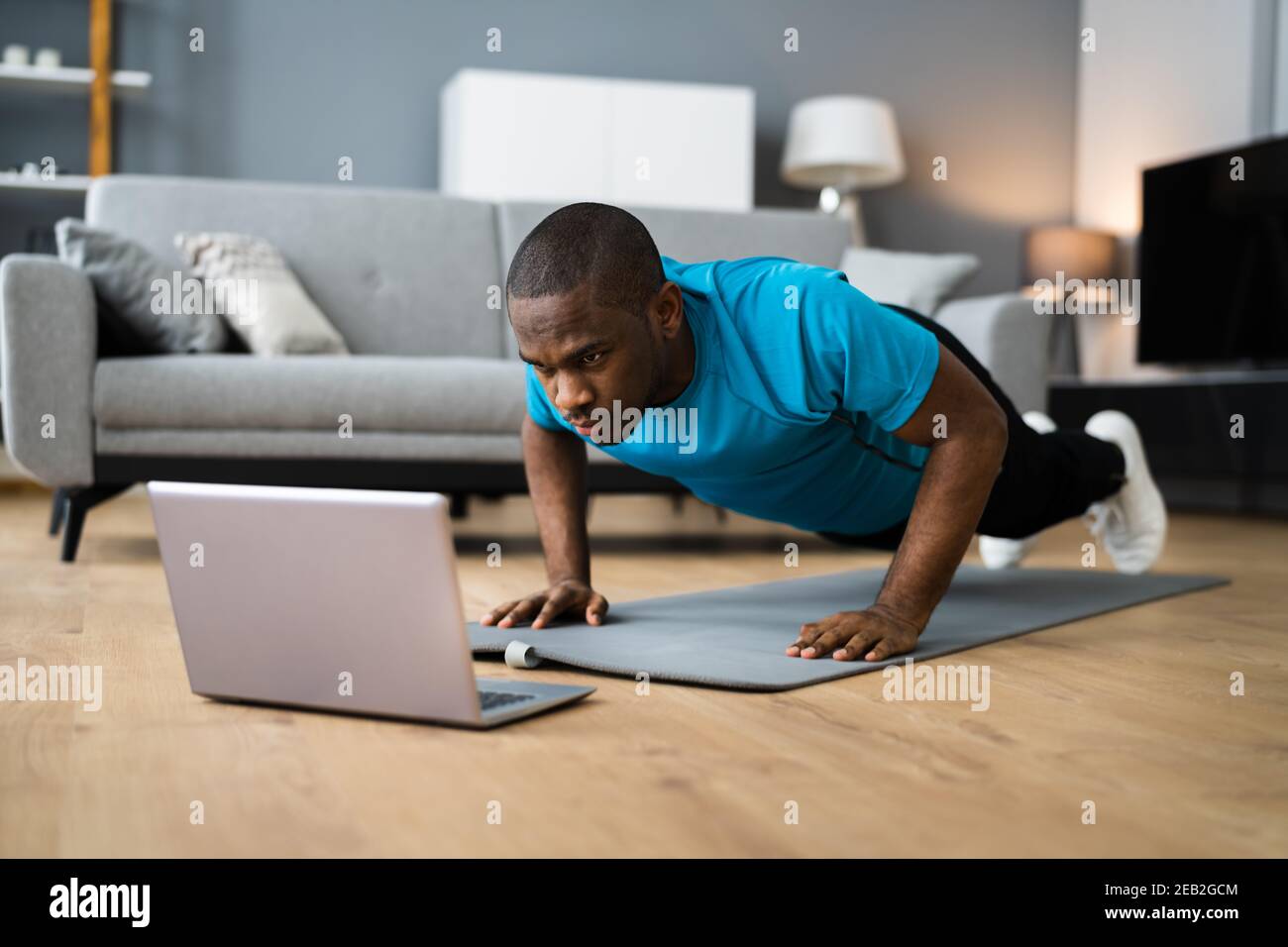 African American Man fare online fitness Pushup workout a casa Foto Stock