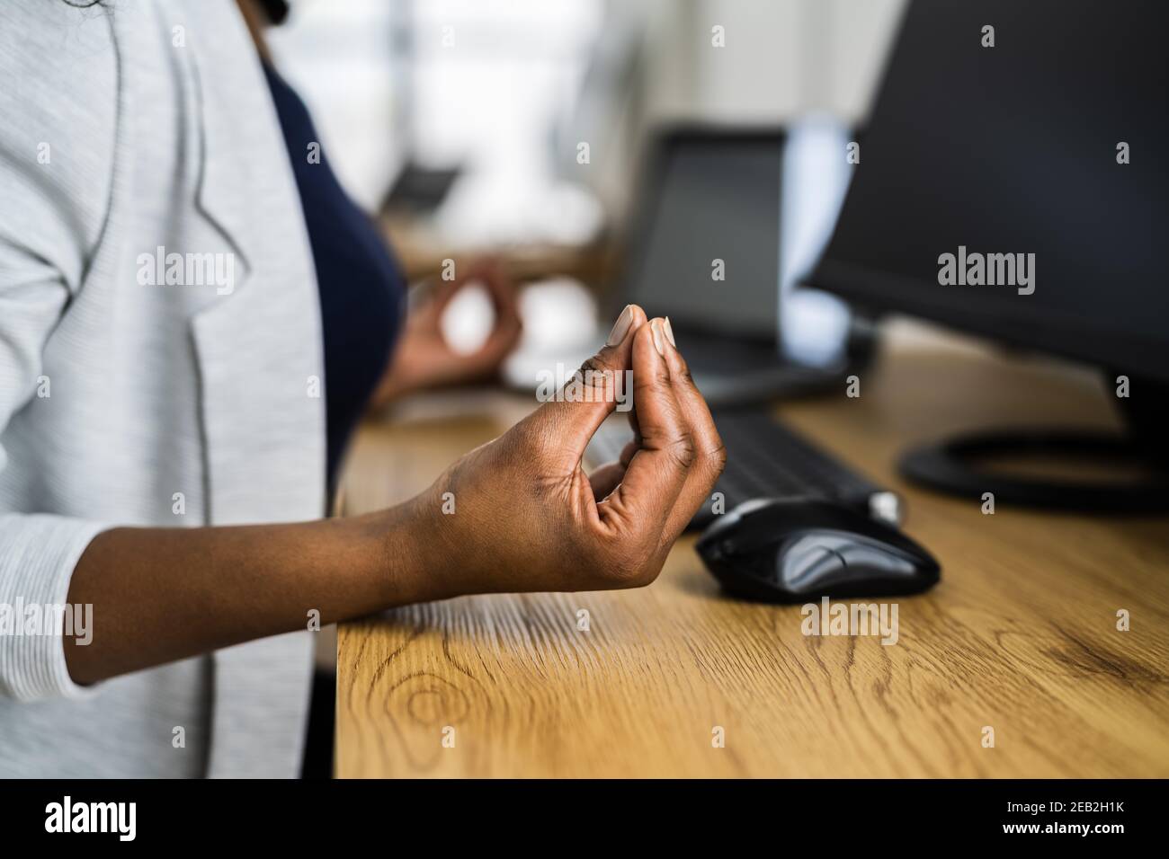 Impiegato di ufficio che fa l'esercitazione mentale e lo Yoga al tavolo Foto Stock