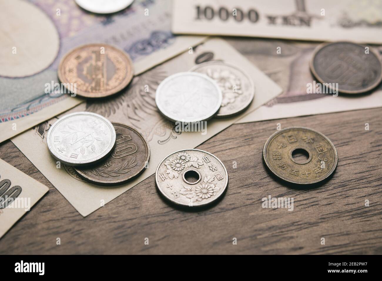 Closeup di yen giapponesi bollette di denaro e monete su legno tabella di base per il concetto finanziario Foto Stock