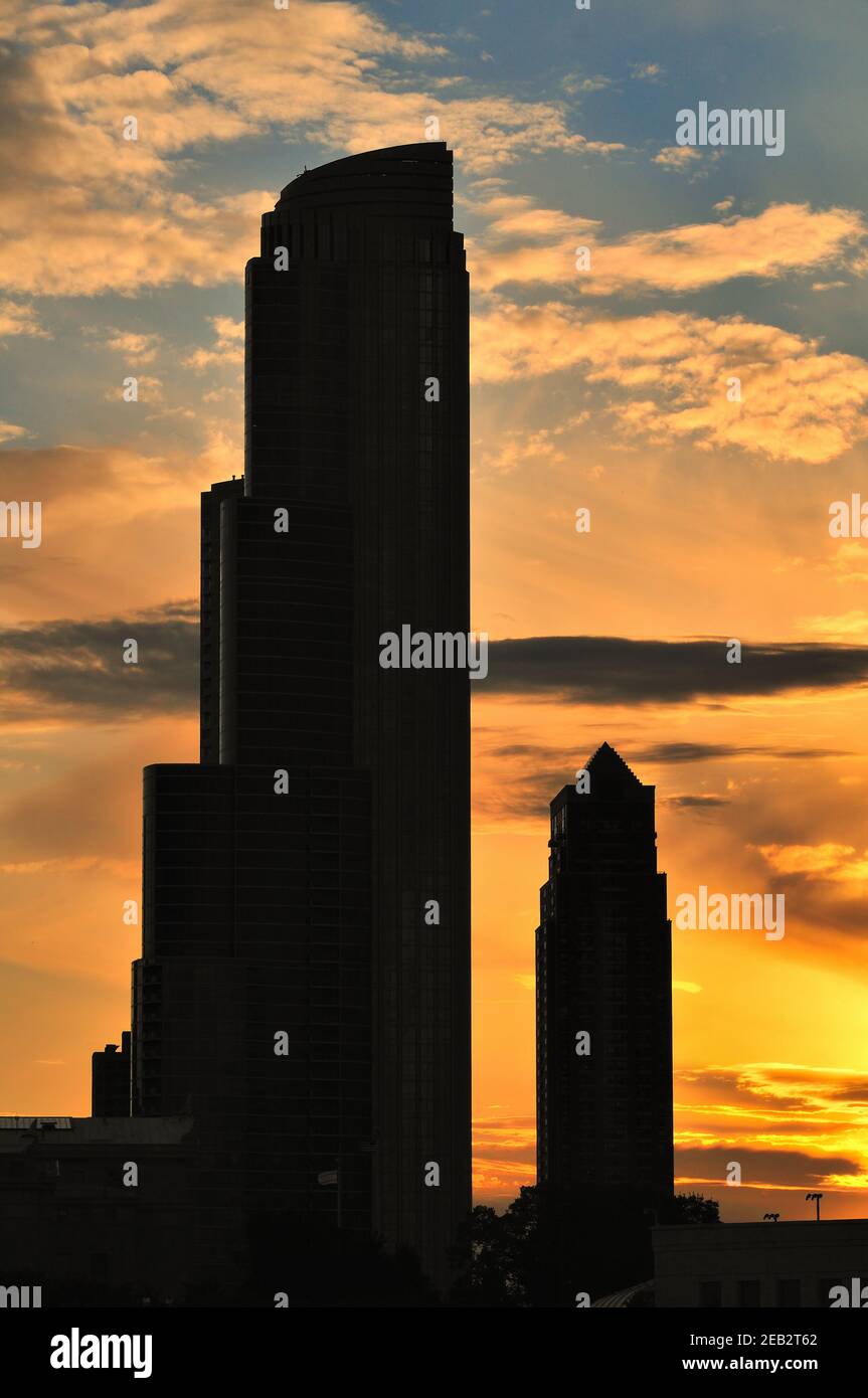 Chicago, Illinois, Stati Uniti. Un tramonto estivo a Chicago dipinge le nuvole di colore oltre due edifici nello skyline di South Loop. Foto Stock