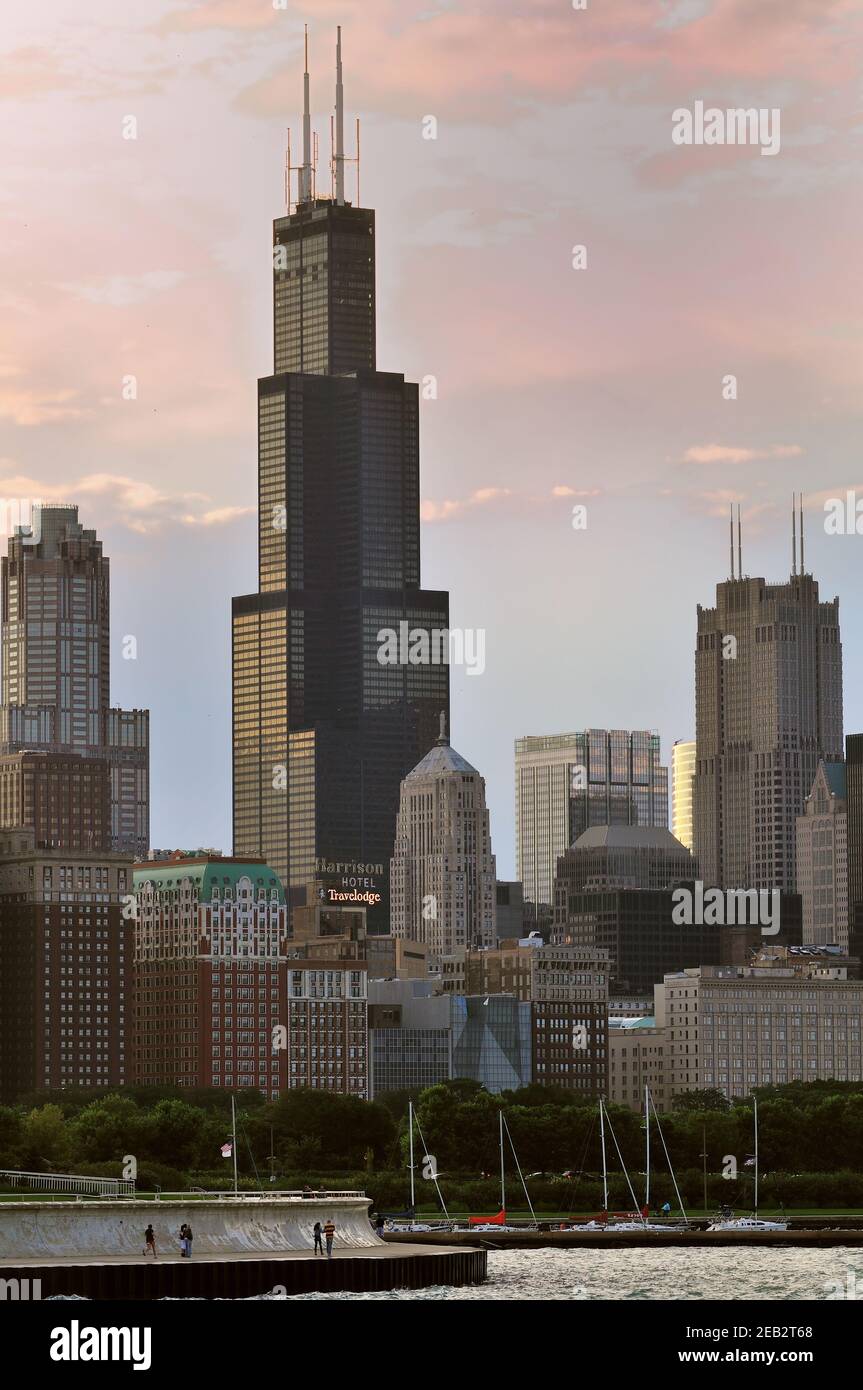 Il sole che tramonta riflette i colori del crepuscolo nella nuvola dietro e sopra la Willis Tower (ex Sears Tower). Foto Stock